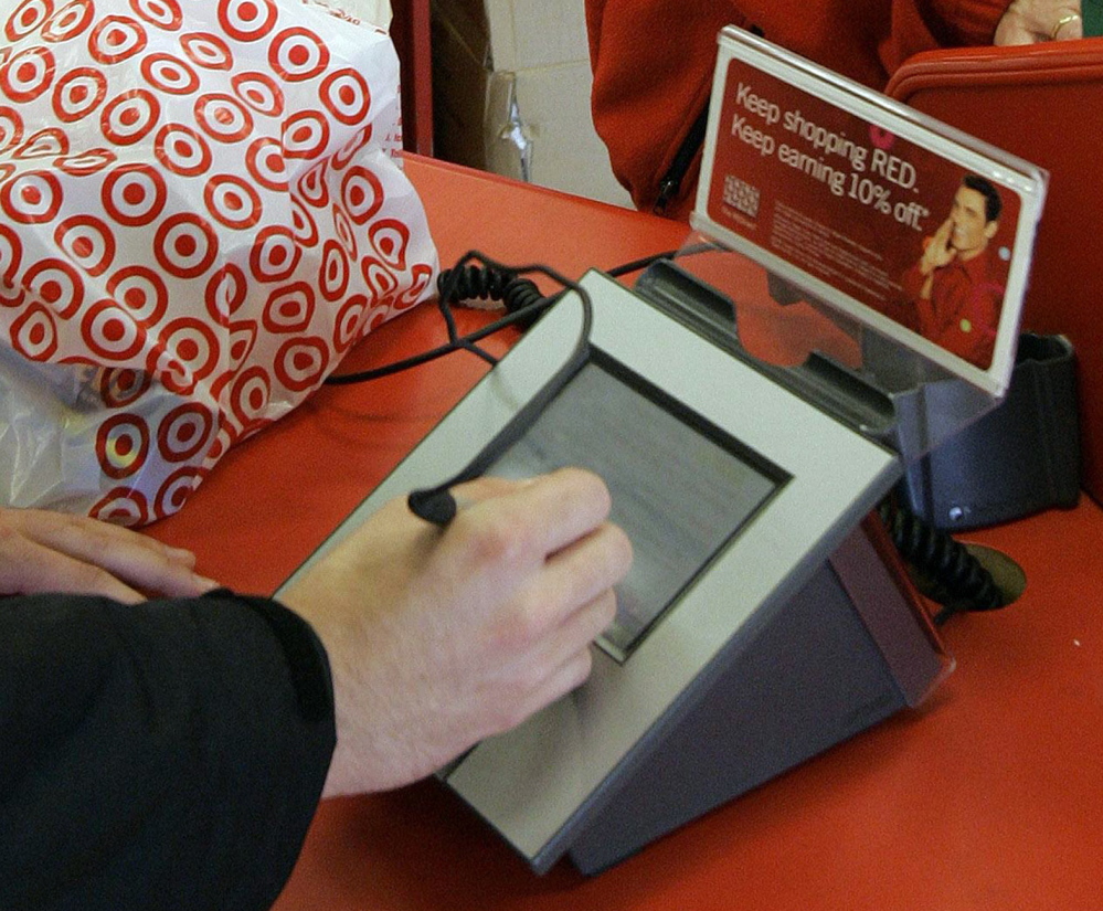 A customer signs his credit card receipt at a Target store. U.S. credit and debit cards are easier to copy, experts say, because of the magnetic strip they use instead of digital chips.