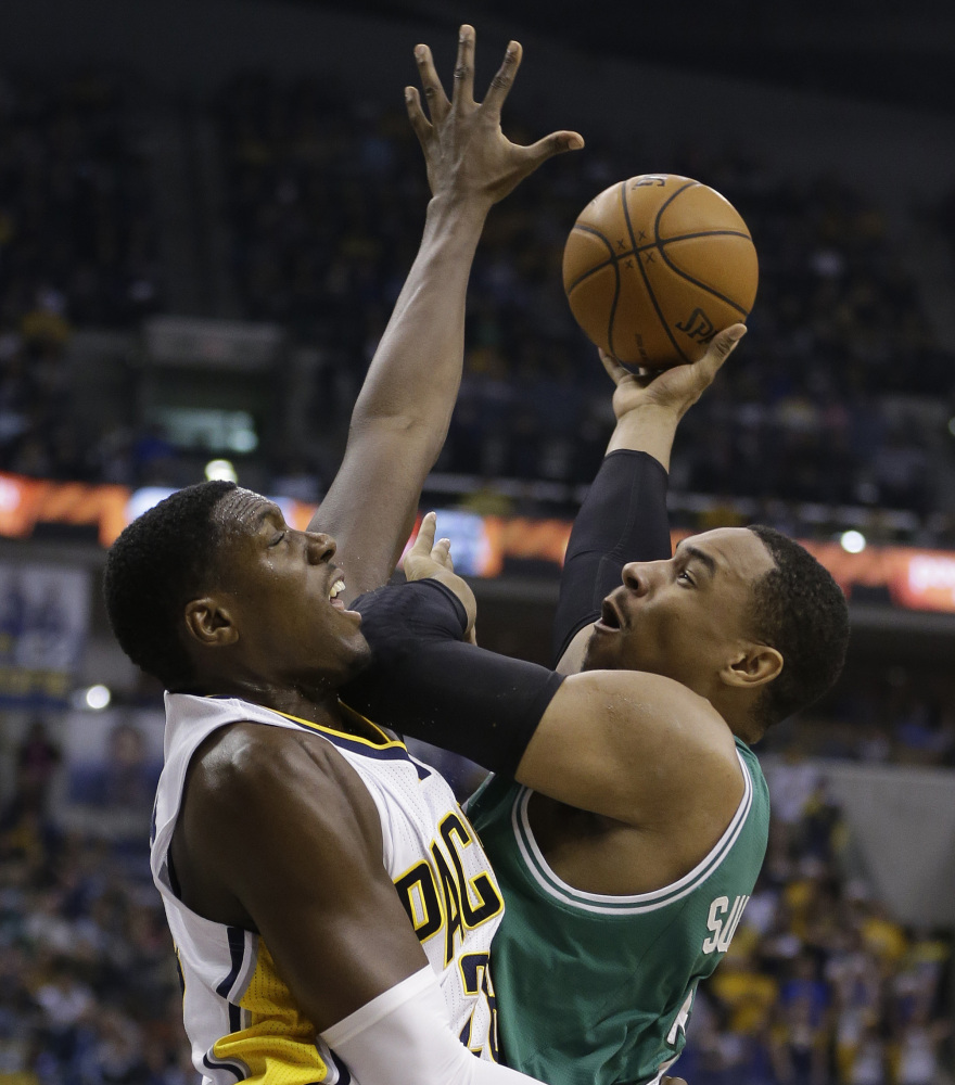 Boston’s Jared Sullinger puts up a shot against the tenacious defense of Indiana’s Ian Mahinmi during the first half of Sunday’s game in Indianapolis.