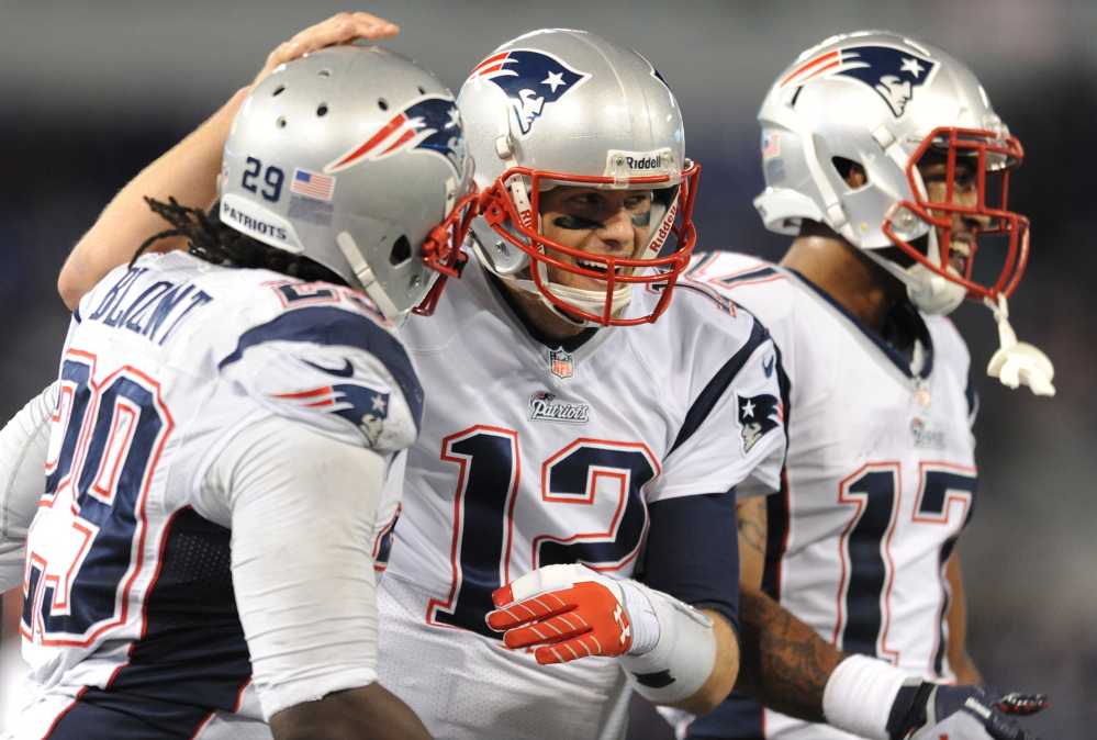 Tom Brady beams with teammates LeGarrette Blount, left, and Aaron Dobson after Blount scored one of his two touchdowns to put the Patriots well on their way to a rout over their AFC rivals Sunday afternoon in Baltimore.