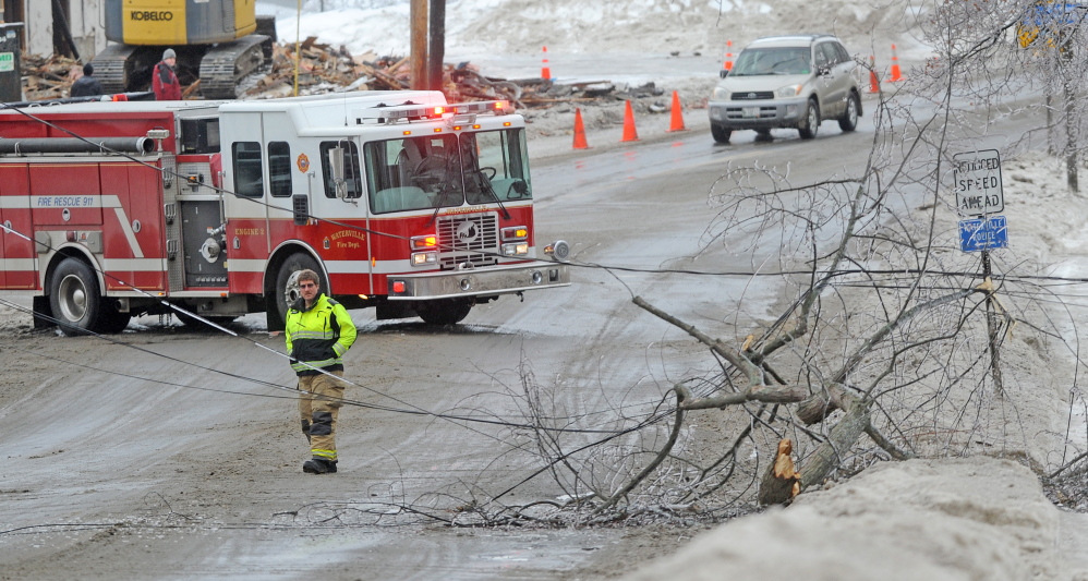 Staff photo by Michael G. Seamans LINES DOWN: The Waterville fire department closed down a section of Main Street in downtown Waterville Monday afternoon after a branch broke under the strain of heavy ice and knocking out power.