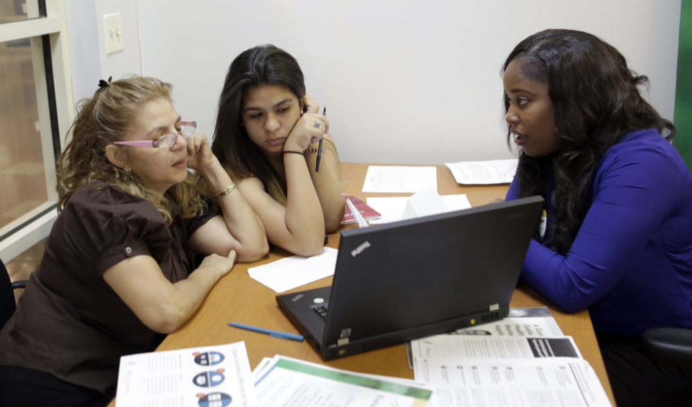Certified enrollment specialist Richelle Baker, right, talks to Martha Medina, left, and her daughter Martha at a Healthcare Insurance Marketplace office in Miami on Friday.