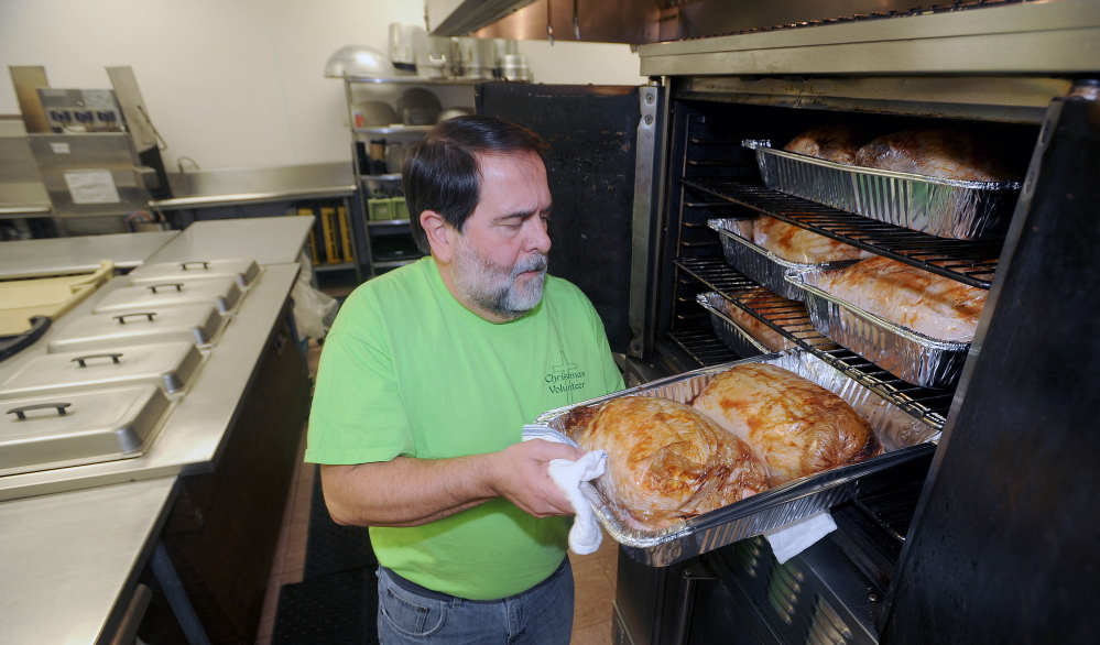 Richard Dionne, kitchen supervisor for the Central Maine Family Christmas Dinner, tends to turkey in the oven at the Elks Lodge in Waterville on Monday. This will be the seventh consecutive year that volunteers have offered a free dinner open to all on Christmas Day.