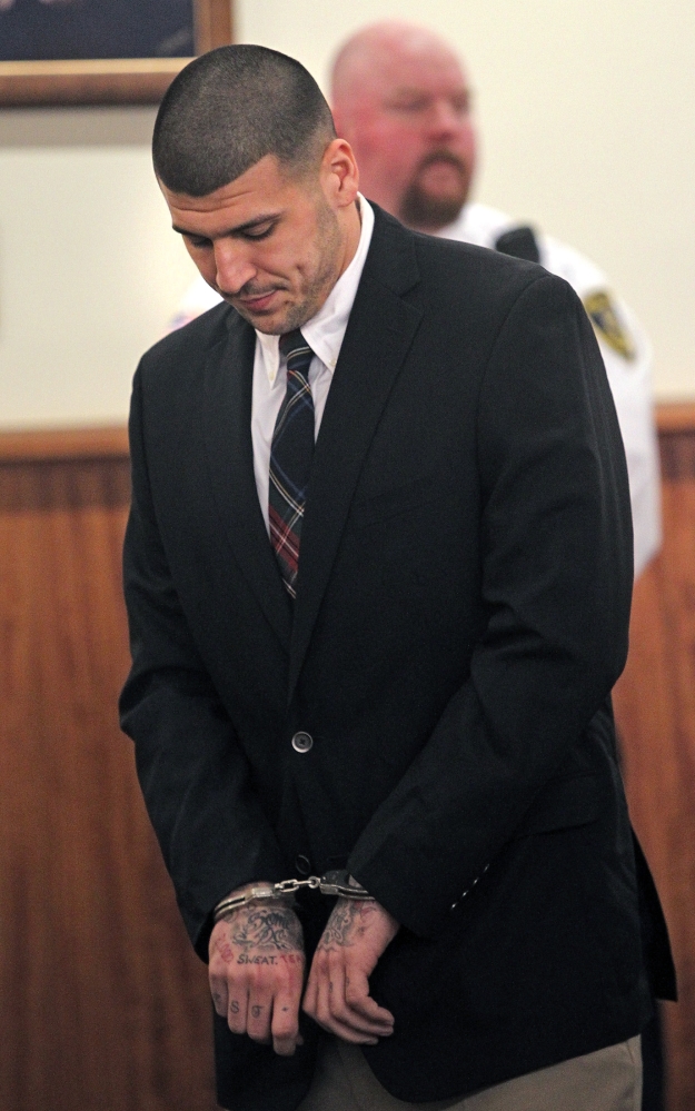 Former New England Patriots football player Aaron Hernandez stands during his court appearance at the Fall River Superior Court in Fall River, Mass., Monday, Dec. 23, 2013. A Massachusetts judge may impose a formal gag order in the murder case against Hernandez, after his attorneys accused the state of allowing leaks that jeopardize his right to a fair trial.