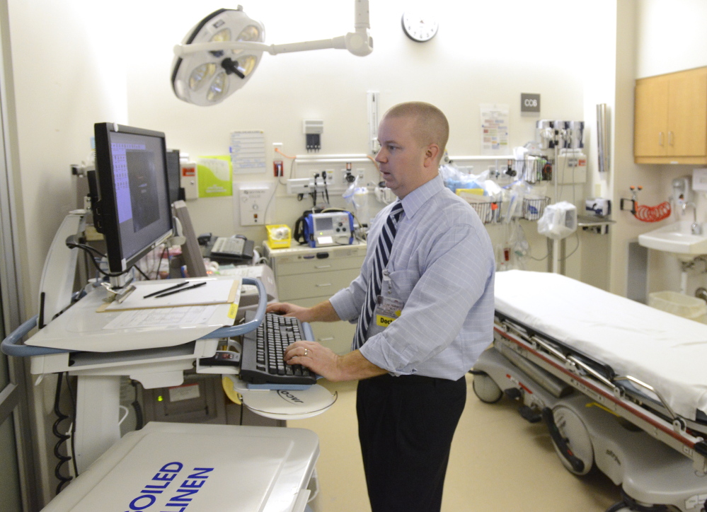 Dr. Nathan Mick of Maine Medical Center uses a new computer system called Epic that makes his work more efficient. Thursday, December 12, 2013. John Patriquin/Staff Photographer.