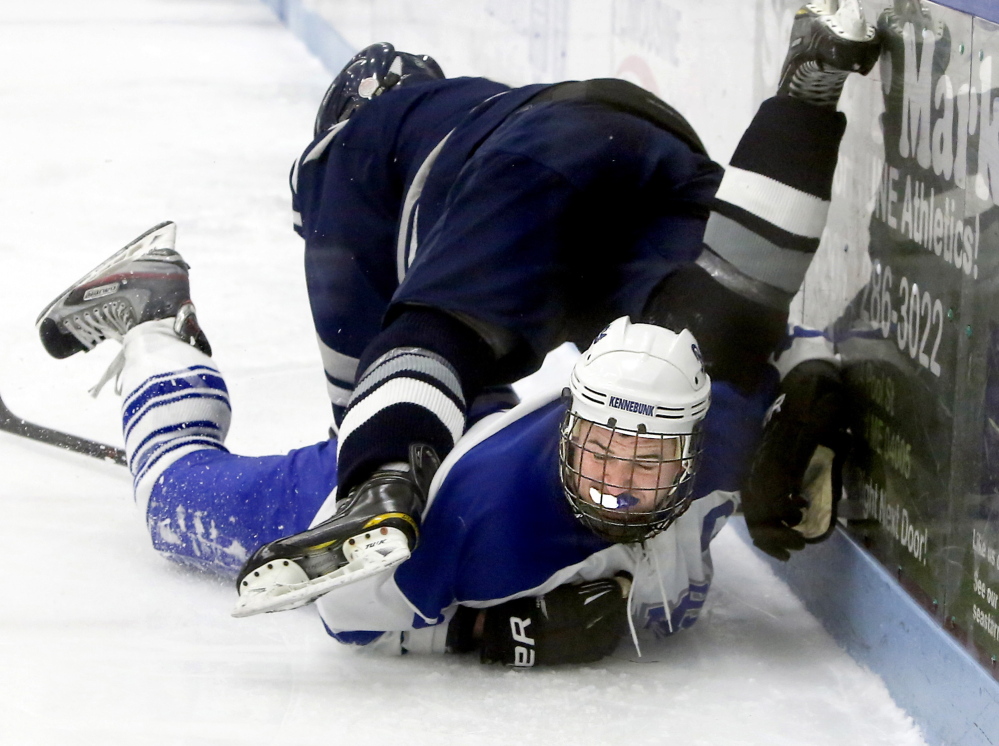 Bryce Fraser of Kennebunk is taken down by a check from Yarmouth’s Max Watson, who picked up an assist on his team’s only goal.