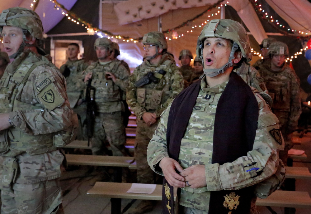 Capt. David DeRienzo, chaplain for the 133rd Engineer Battalion of the Maine Army National Guard, leads his congregation in prayer during a Christmas Eve service at battalion headquarters at Bagram Air Field in Afghanistan on Tuesday.