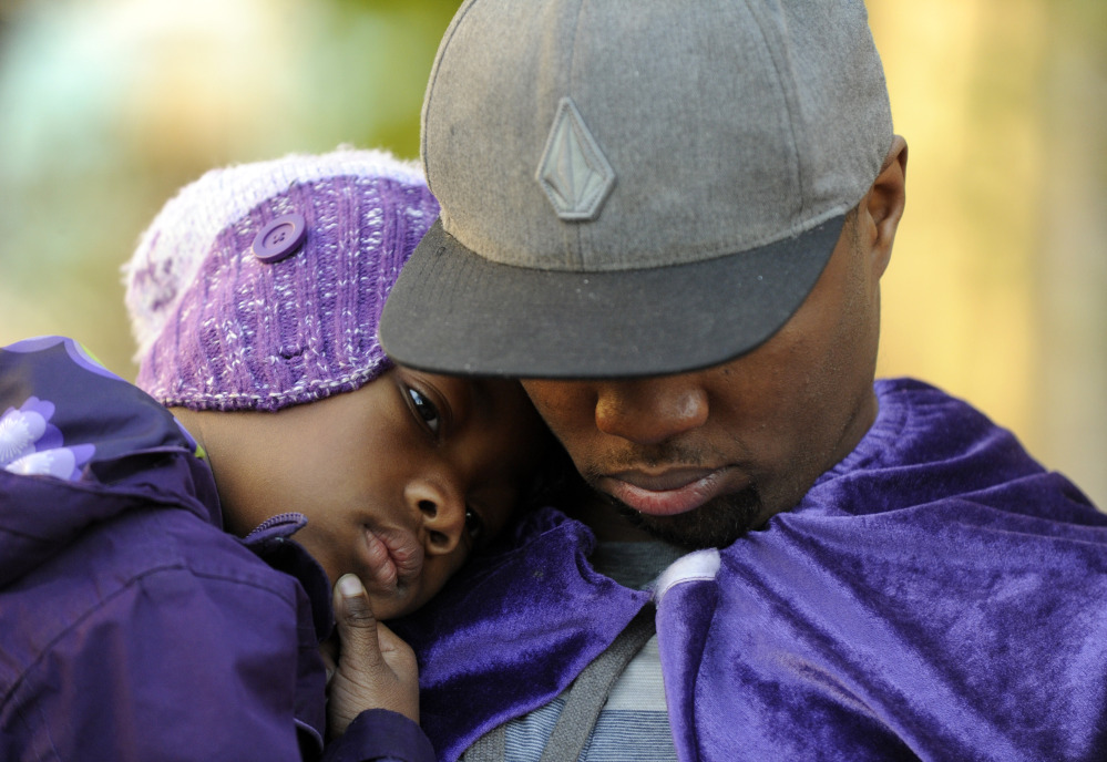 Quinton Reynolds, of Emeryville, Calif., holds his daughter Qniyah Reynolds, 4, outside of Children’s Hospital Oakland in support of Jahi McMath in Oakland, Calif., on Monday.