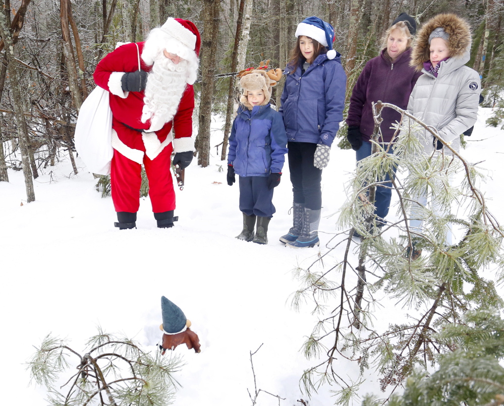 Santa talks to one of his elves as he leads a group of kids and adults on the newly completed sections of the West End Trail in Yarmouth on Dec. 24, 2013. 