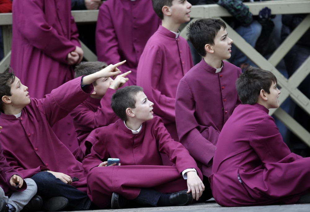 Altar boys wait for Pope Francis to deliver his “Urbi et Orbi” (to the City and to the World) message from the central balcony of St. Peter’s Basilica at the Vatican, Wednesday, Dec. 25, 2013. Pope Francis on Christmas day is wishing for a better world, with peace for the land of Jesus’ birth, for Syria and Africa as well as for the dignity of migrants and refugees fleeing misery and conflict. Francis spoke from the central balcony of St. Peter’s Basilica Wednesday to tens of thousands of tourists, pilgrims and Romans in the square below. He said he was joining in the song of Christmas angels with all those hoping “for a better world,” and with those who “care for others, humbly.”