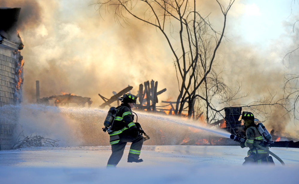 Firefighters battle a fire at 160 Drummond Ave. in Waterville on Wednesday.