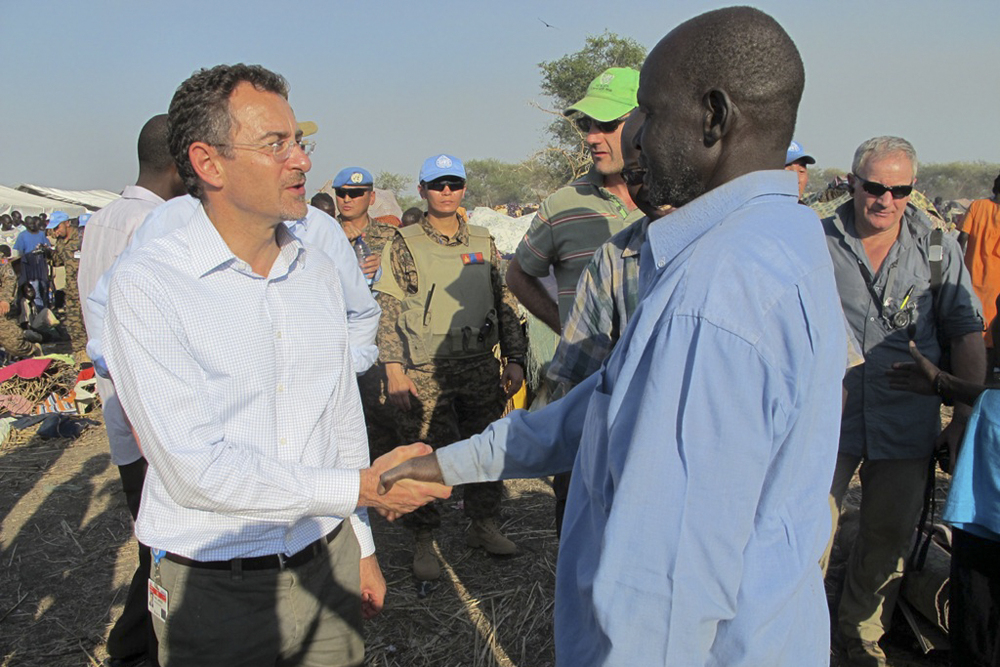 In this photo taken Tuesday, Dec. 24, 2013 and released by the United Nations Mission in South Sudan (UNMISS) on Wednesday, Dec. 25, 2013, the U.N.'s top humanitarian official in the country Toby Lanzer, left, makes a visit to assess the humanitarian situation at the U.N. compound where many displaced have sought shelter in Bentiu, in oil-rich Unity state, in South Sudan. In New York, the U.N. Security Council voted unanimously Tuesday to beef up its peacekeeping force in South Sudan and condemned targeted violence against civilians and ethnic communities and called for "an immediate cessation of hostilities and the immediate opening of a dialogue." (AP Photo/UNMISS, Anna Adhikari)