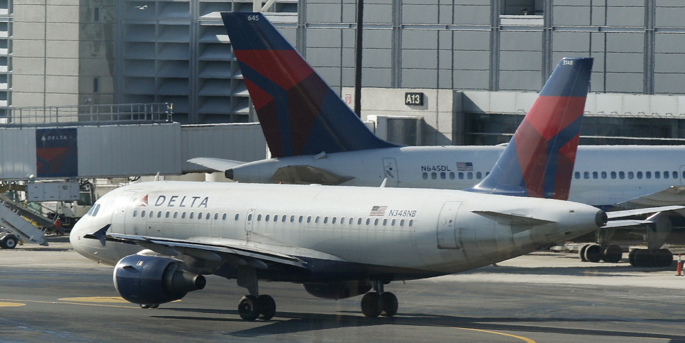 In this file photo, a Delta Airlines plane taxis past a gate at Logan Airport in Boston. Massachusetts Port Authority officials say they are preparing to celebrate more than 29.6 million passengers passing through the airport this year, a record for Logan.