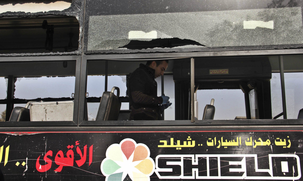 An Egyptian inspector takes notes Thursday inside a public bus that was hit by an explosion earlier in the day in the eastern Nasr City district of Cairo.