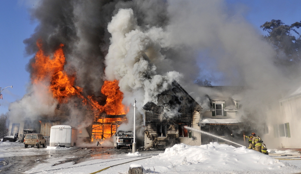 Firefighters from Waterville battle a blaze at 160 Drummond Ave. in Waterville on Wednesday. Officials say the fire was started by woodstove ashes.