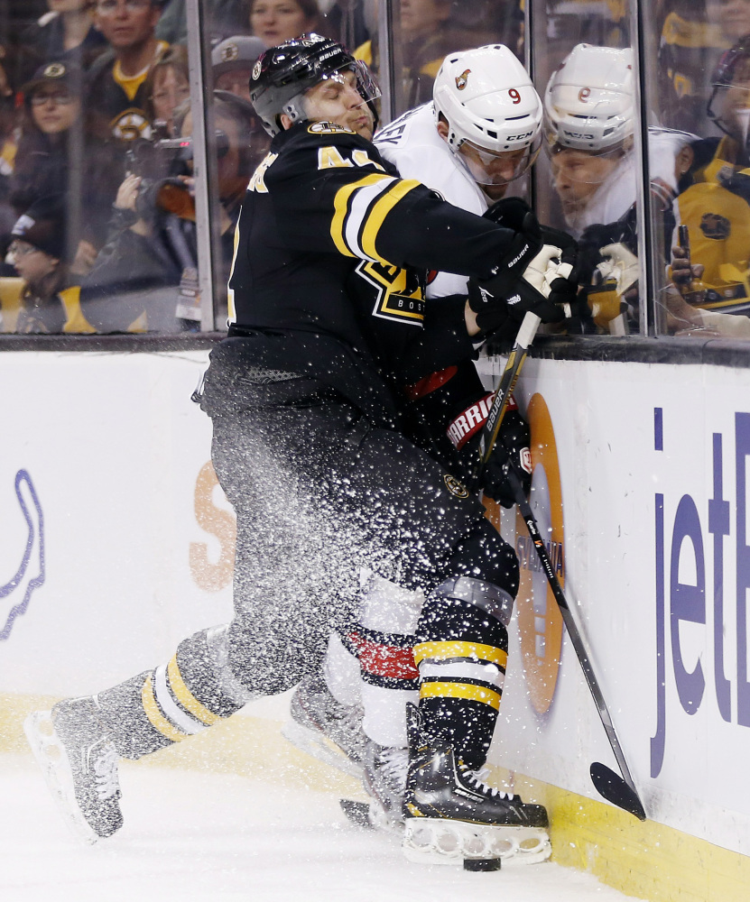 Boston Bruins’ Dennis Seidenberg (44) checks Ottawa Senators’ Milan Michalek (9) in the first period Friday.