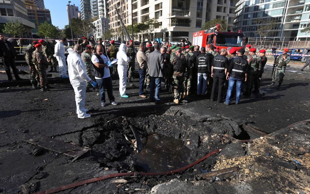 Lebanese army investigators in white coveralls stand at the scene of an explosion in Beirut on Friday that killed a prominent pro-Western politician. Mohammed Chatah, 62, was also a former Lebanese ambassador to the U.S. and a senior aide to ex-Prime Minister Saad Hariri.