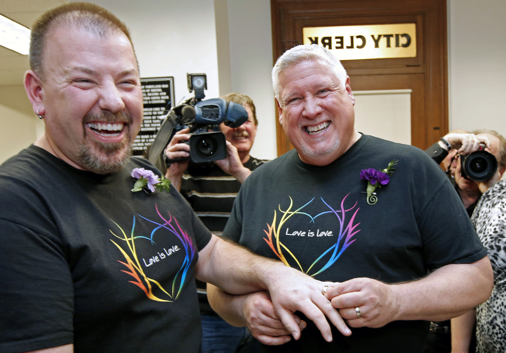 Steven Bridges, left, receives a wedding ring from Michael Snell at Portland City Hall in 2012. Crowds cheered them after they become the first same-sex couple to be married in the state.