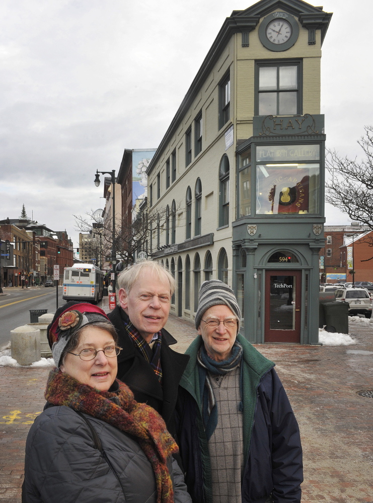 Greater Portland Landmarks will host a photography show at the Portland Public Library in January. Curators Susan Danly (left), Earle Shettleworth and Bruce Brown, who juried the exhibition, stand in front of Portland's Hay Building on Congress Street in Portland. Tuesday, December 24, 2013.