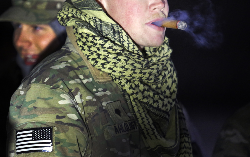 Spc. Carl Ahlquist of Scarborough enjoys a cigar before setting out from Bagram Air Field with the Convoy Escort Team on Dec. 20.