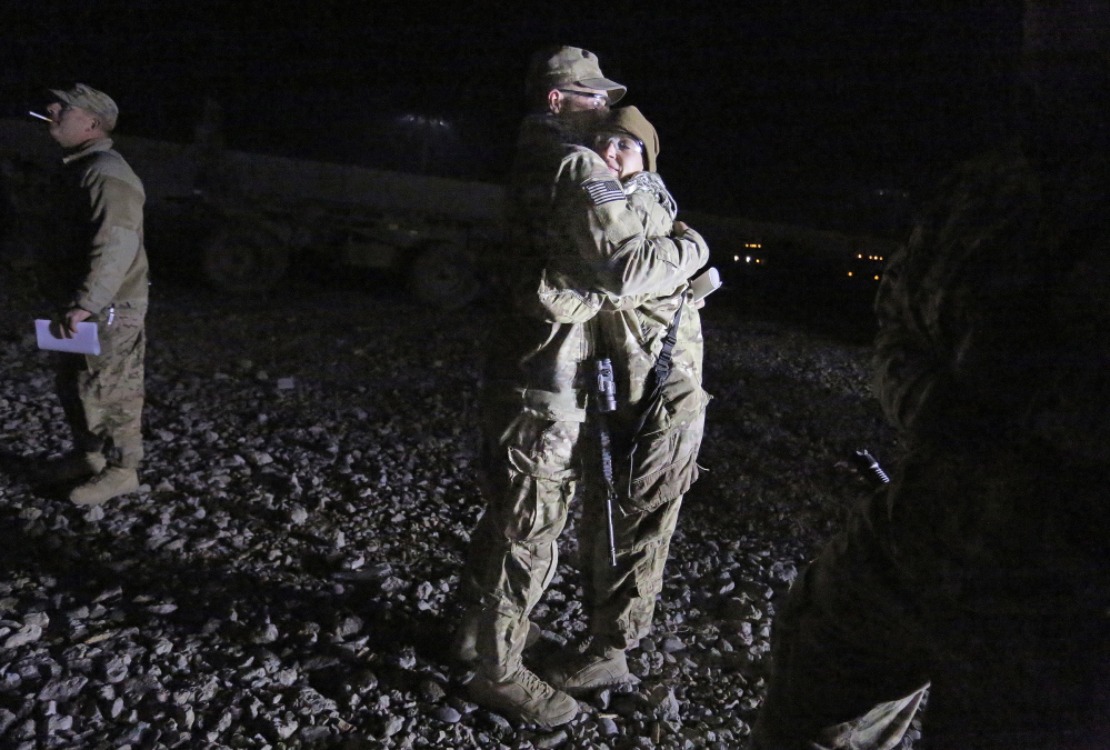 Sgt. Robert Kurka and his wife, Sgt. Jessica Kurka, both of Durham, embrace as Robert prepares to leave with the convoy late on Dec. 20. South of Kabul, the convoy would run into snow, which adds to the danger of such trips because snow can effectively hide IEDs.