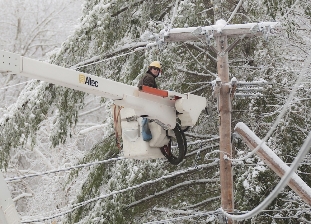 Maine Public Service lineman Craig Hobbs works to restore power on the Perkins Point Road off Brewer Lake in Orrington onSunday, Dec. 29. 2013.