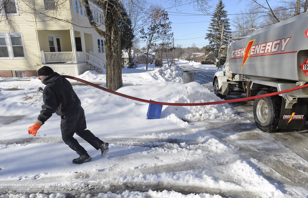 Tim Darnell of Cash Energy heads up a snowy, icy driveway Monday while delivering oil in Portland. Steep and slick driveways and snow-clogged back roads are making deliveries difficult in some areas.