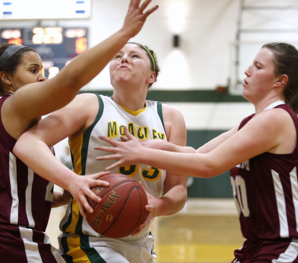 Victoria Lux of McAuley powers her way to the basket between Windham defenders Lonnie Staten, left, and Sadie Nelson on Monday.