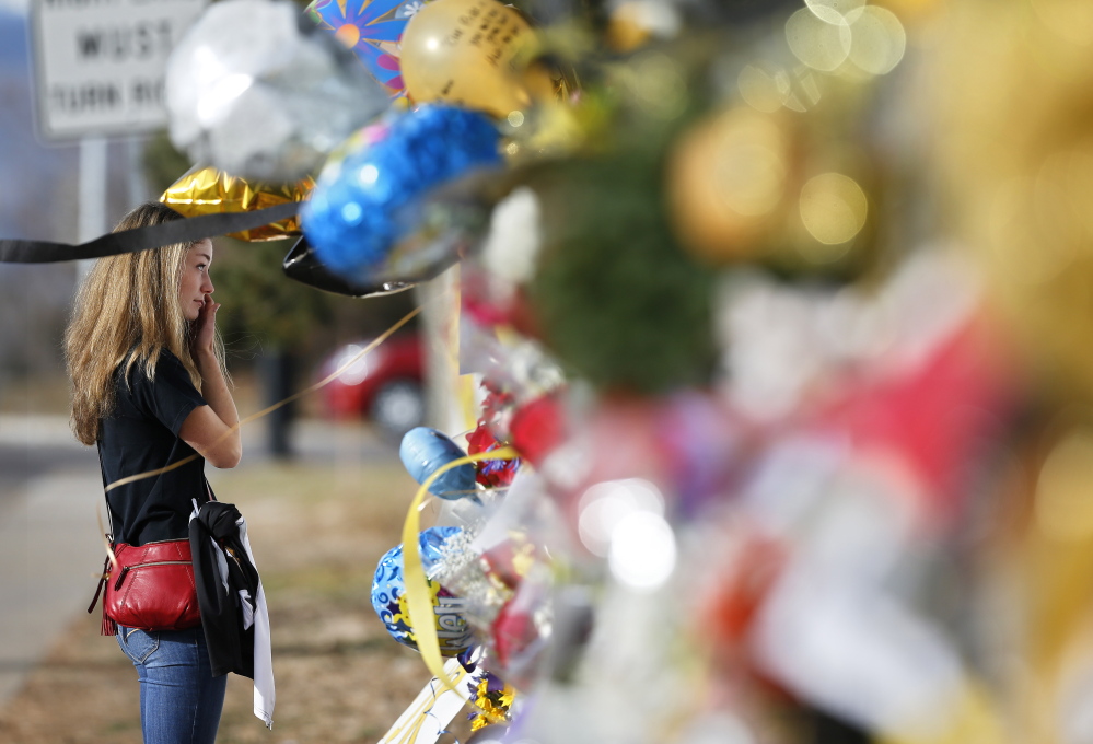 Arapahoe High School student body vice president Grace Marlowe looks at a tribute site for student Claire Davis on Dec. 19, six days after she was shot by a classmate during a school attack, in Centennial, Colo.