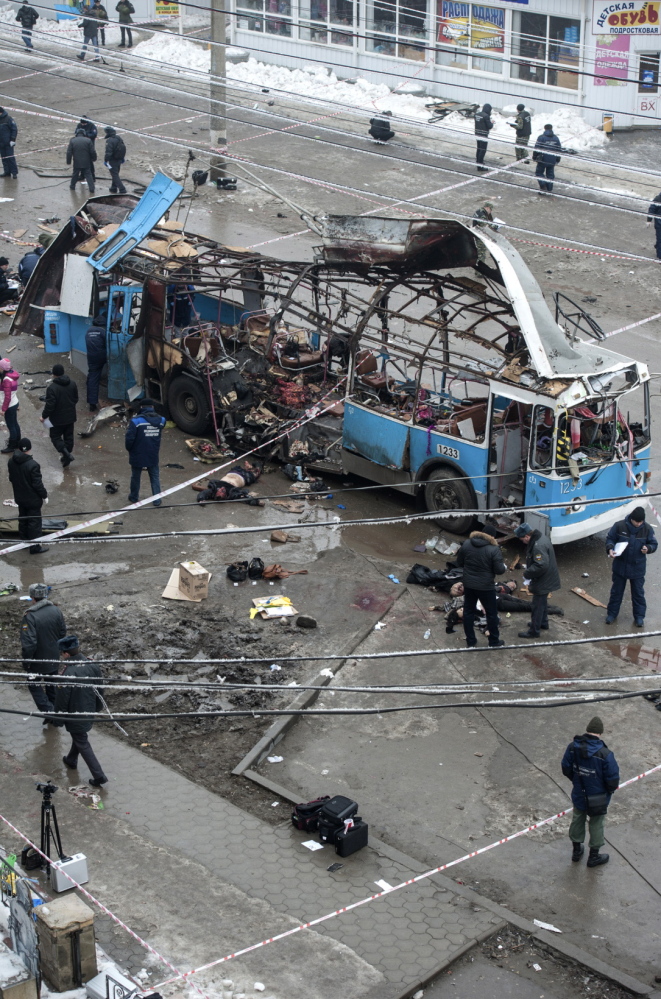 Investigators go through the wreckage of a bus destroyed by a suicide bomber in Volgograd on Monday, killing 14. A bombing the day before killed 17 in the city.