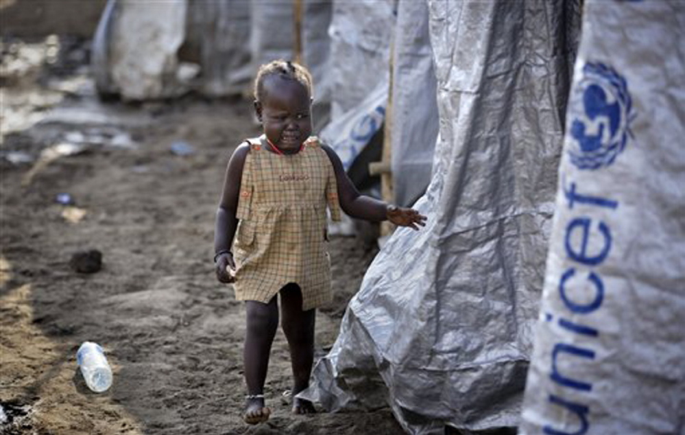 A young displaced girl starts crying after the relative she was with disappears into a row of latrines, at a United Nations compound which has become home to thousands of people displaced by the recent fighting, in the capital Juba, South Sudan Sunday.