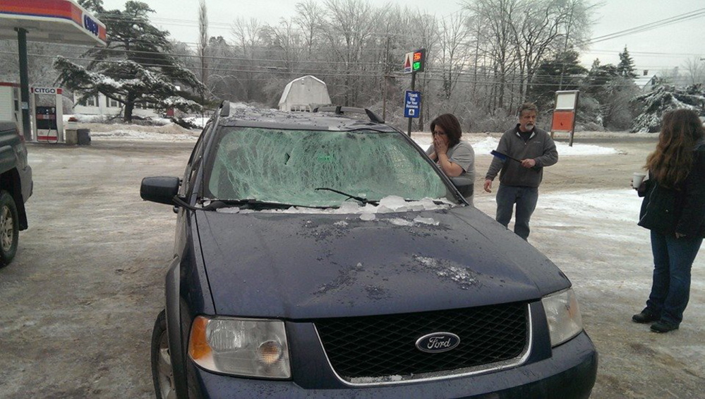 People check out a car hit by ice on the Penobscot Narrows Bridge on Sunday.