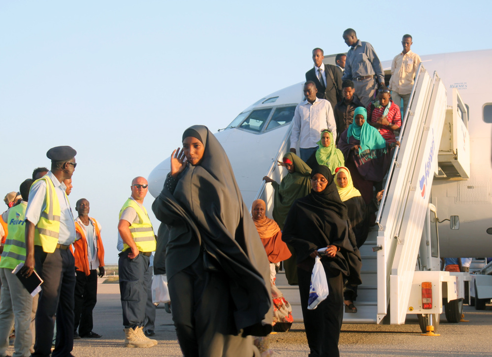 Somali who fled from South Sudan’s fighting get off a plane at Mogadishu’s International airport, Monday, Dec, 30, 2013. The Somali government has evacuated up to 150 Somalis who escaped from the fighting between South Sudanese government troops and rebel fighters.