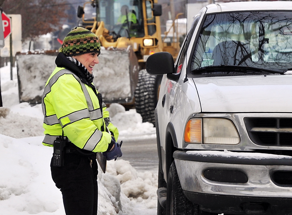 Dressed for the cold weather, Ann Rand, parking control officer for Portland, coordinates the towing of a truck parked in a city services tow zone on North Street as crews atempt to remove snow from the last two storms. Her comment: “It’s cold!”