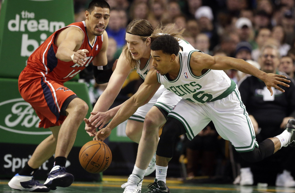 Atlanta Hawks forward Gustavo Ayon, left, and Boston Celtics center Kelly Olynyk, center, and guard Phil Pressey chase a loose ball in the second quarter of an NBA basketball game Tuesday in Boston.