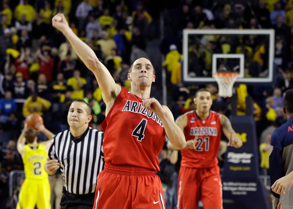 Arizona guard T.J. McConnell (4) celebrates after the Wildcats defeated Michigan 72-70 in Saturday's college basketball game in Ann Arbor, Mich.