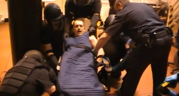 Paul Schlosser III is restrained after being removed from his cell.