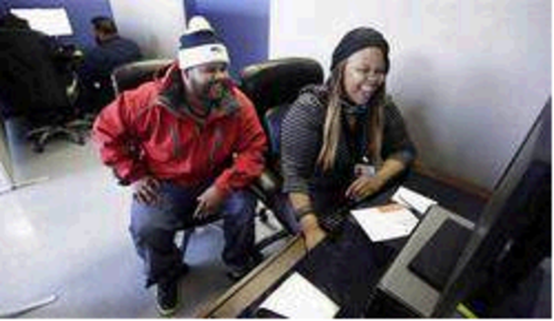 Kenya Williams helps unemployed construction worker Jerome Davis Jr., 36, sign up for Medicaid under expanded eligibility rules in Chicago on Nov. 8. Maine would be better off accepting federal funds to expand MaineCare than spending $1 million to review DHHS programs, a reader says.