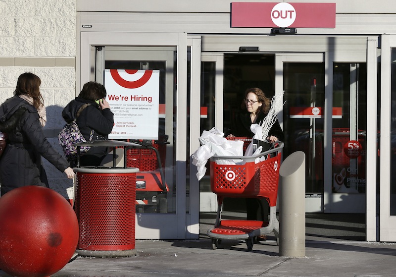 A woman pushes a shopping cart, right, while departing a Target retail store Thursday, Dec. 19, 2013 in Watertown, Mass. The nation’s second-largest discount retailer said Tuesday that an unidentified number of gift cards sold over the holidays were not properly activated.