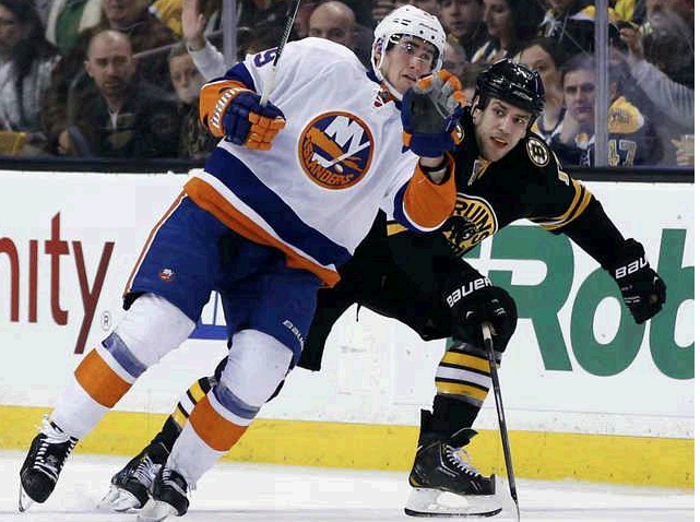 New York Islanders center Brock Nelson and Boston Bruins left wing Milan Lucic make contact as they skate down the ice during the third period in Boston on Tuesday.