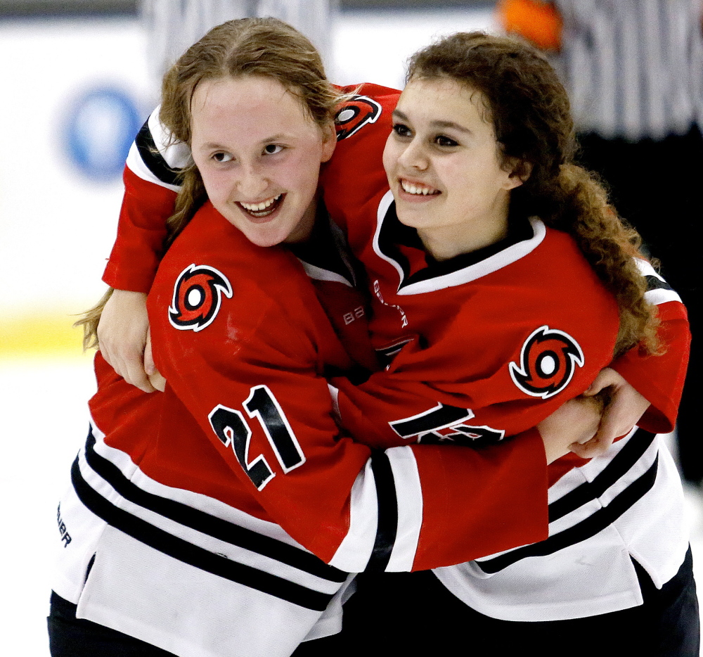 Scarborough’s Samantha Shoebottom and Madison O’Reilly embrace after the Red Storm defeated Lewiston 3-1 in the girls’ hockey championship in Lewiston on Saturday.