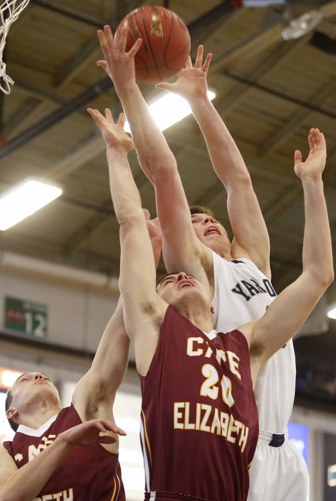Yarmouth’s Nate Shields-Auble, right, goes above Cape Elizabeth’s Justin Guerette, center, and Ethan Murphy, left, during the Clippers’ 45-43 victory Saturday in the Western Class B quarterfinals.