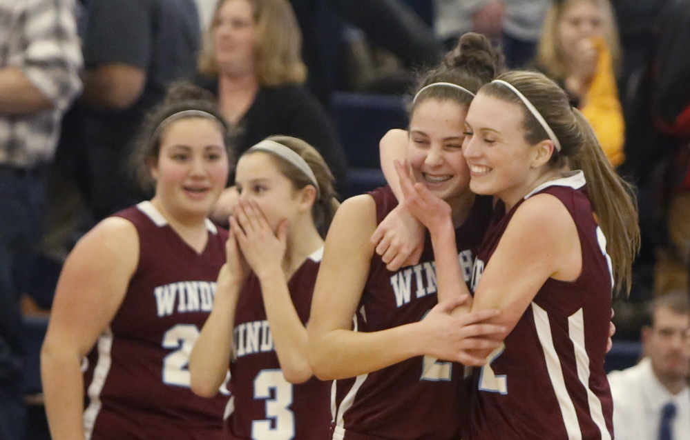 Sam Frost, right, and Luisa Sbardella hug after Windham beat Thornton Academy 34-32 in a Western Class A girls’ basketball quarterfinal Monday at the Portland Expo.