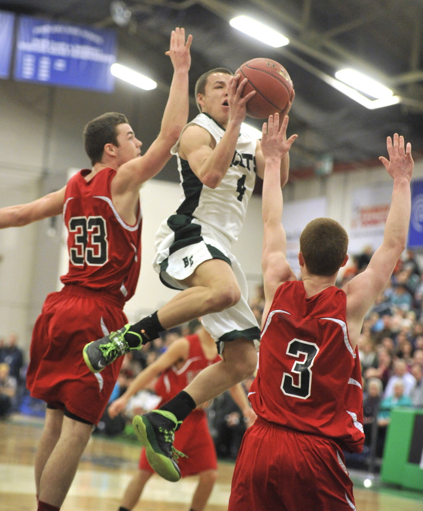 Dustin Cole goes up for a layup against Sanford’s Joshua Schroder, left, and Evyn Nolette during Bonny Eagle’s 66-49 win Monday morning in a Western Class A boys’ basketball quarterfinal at the Portland Expo. Cole scored 33 points to help the Scots advance to the semifinals against Falmouth.