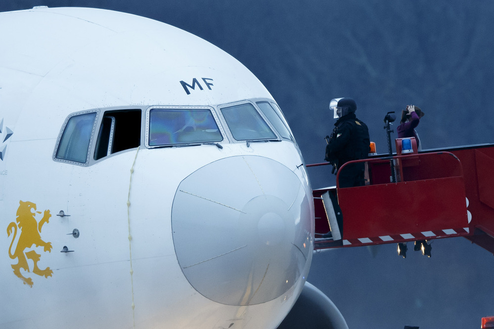 Police stand on the stairs after passengers were evacuated from a hijacked Ethiopian Airlines Plane on the airport in Geneva, Switzerland, on Monday.