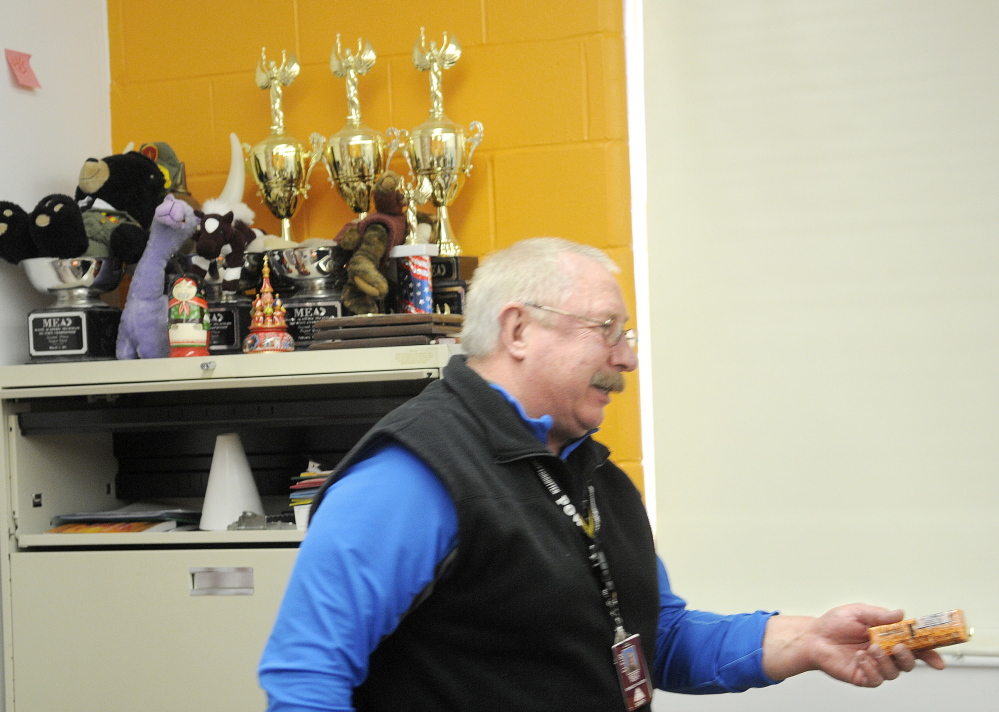 Retired teacher and Academic Decathlon coach Scott Foyt hands out crackers to Monmouth Academy’s Academic Decathon team during a recent practice. Foyt and his wife, Cathy, have coached the school’s team for several years at the Monmouth school.