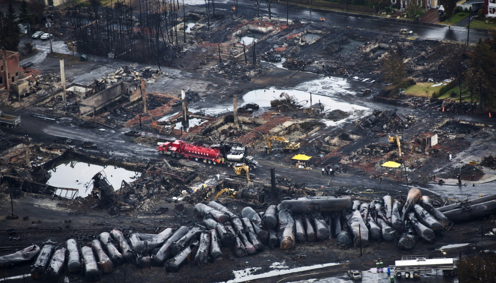 2013 Associated Press File Photo Workers comb through debris after an oil train derailed and exploded in the town of Lac-Megantic, Quebec, last July, killing 47 people. More trains are being used to ship oil, and they travel through populated areas.