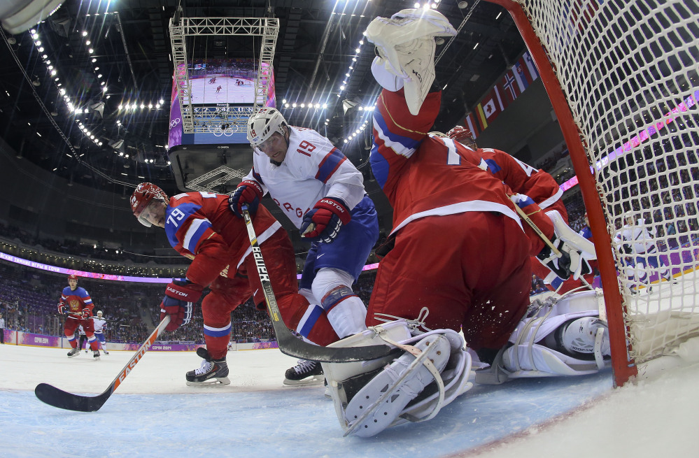 Russia goaltender Sergei Bobrovski clears the puck away from Norway forward Per-Age Skroder as Russia defenseman Andrei Markov helps defend in the third period of a men’s ice hockey game at the 2014 Winter Olympics, Tuesday, Feb. 18, 2014, in Sochi, Russia. Russia won 4-0 to advance to the quarterfinals.