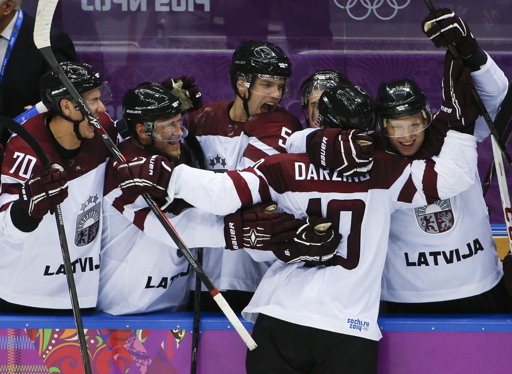 Latvia forward Lauris Darzins is congratulated by teammates after scoring against Switzerland in the third period of a men’s ice hockey game at the 2014 Winter Olympics on Tuesday in Sochi, Russia. Latvia won 3-1 to advance to the quarterfinals.
