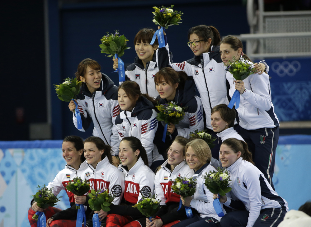 The South Korean team, top left, the Canadian team, front left, and the Italian team, top and bottom right, pose for photographers during the flower ceremony for the women’s 3000m short track speedskating relay final at the Iceberg Skating Palace during the 2014 Winter Olympics, Tuesday, Feb. 18, 2014, in Sochi, Russia. South Korea placed first, followed by Canada and Italy.