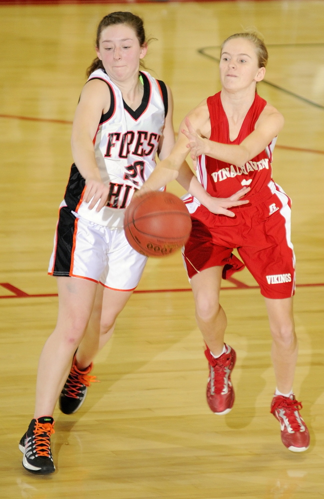 Forest Hills guard Keely Taylor, left, knocks the ball away from Vinalhaven’s Hannah Noyes during a Western Class D girls’ basketball quarterfinal Tuesday at the Augusta Civic Center. Top-seeded Forest Hills won, 70-27.